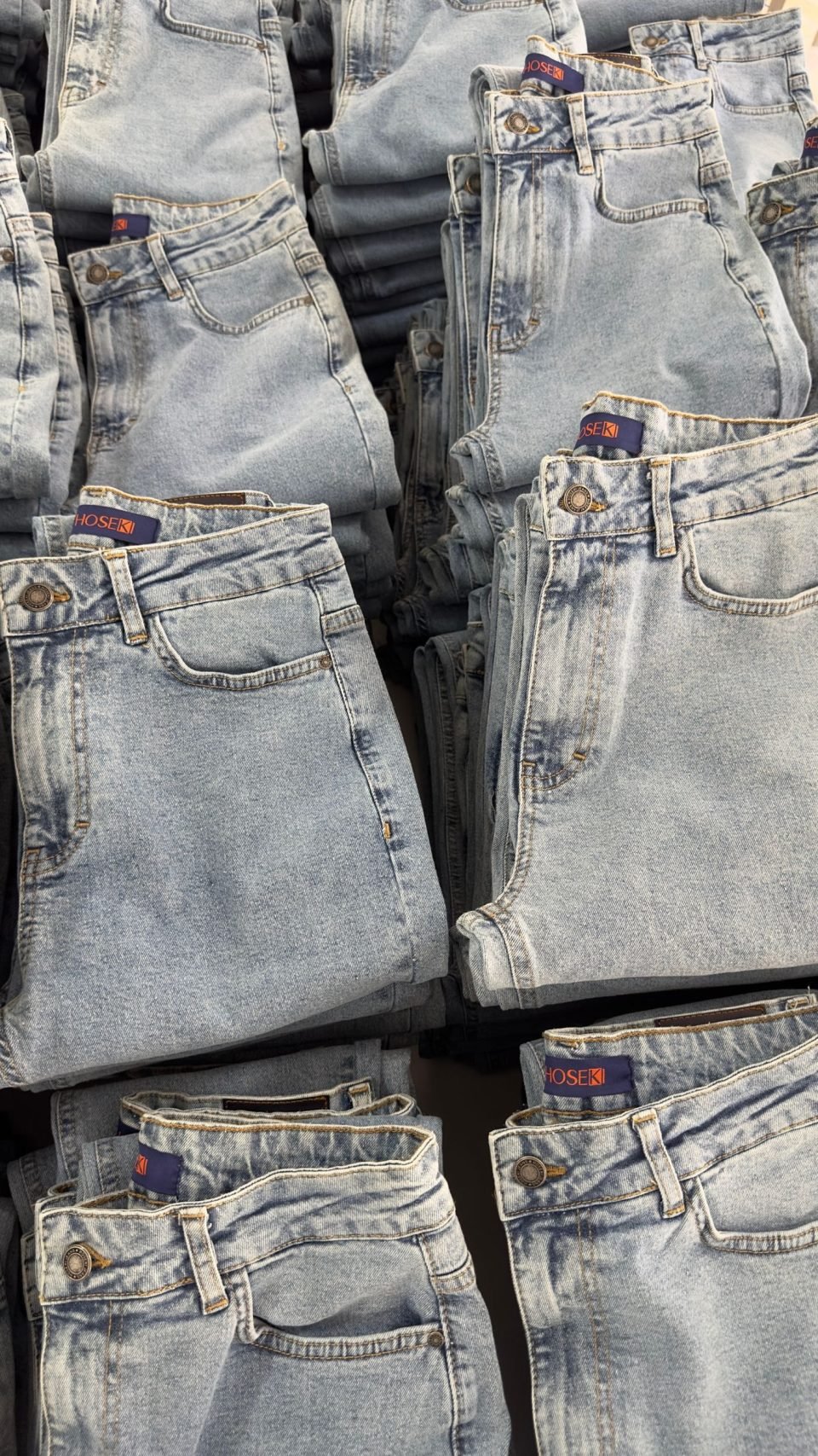 Folded blue jeans stacked neatly on a retail display