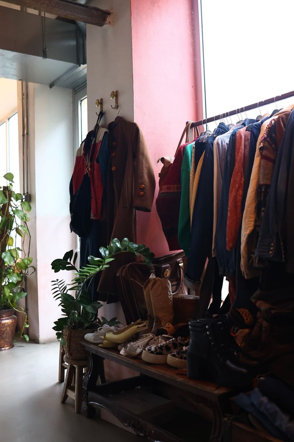 A vintage clothing store with racks of colourful jackets, coats and shoes