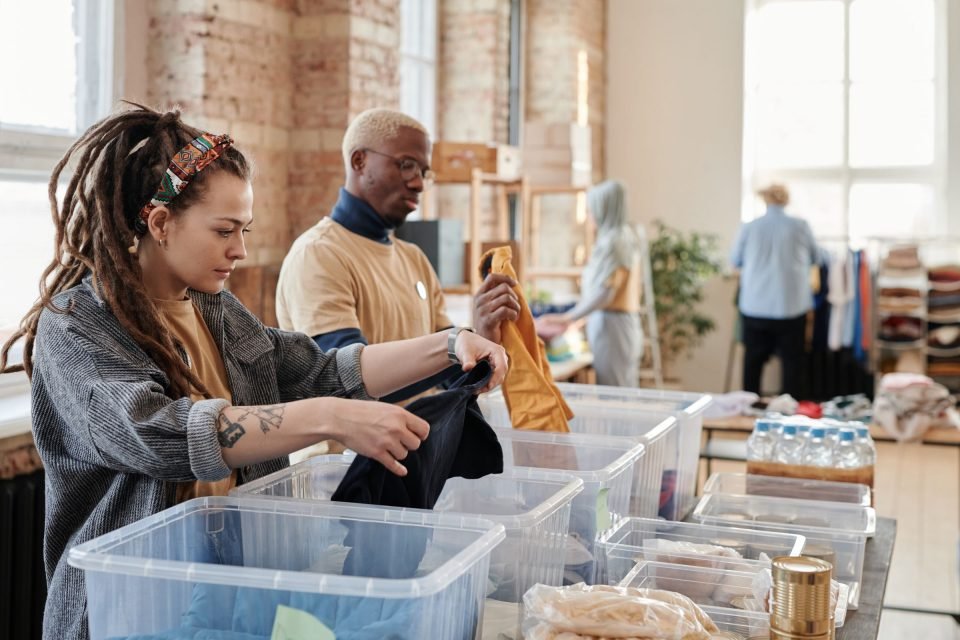 People sorting pre-owned clothing into boxes